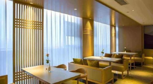 a restaurant with tables and chairs and windows at Jinjiang Inn Select Kunming High-speed South Railway University Town in Kunming