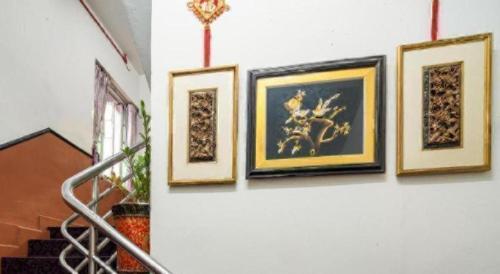 a group of framed pictures on a wall at Meriton Hotel in Singapore