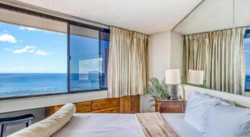 a bedroom with a bed and a large window at Marina Tower Waikiki in Honolulu