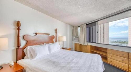 a bedroom with a large bed and a large window at Marina Tower Waikiki in Honolulu