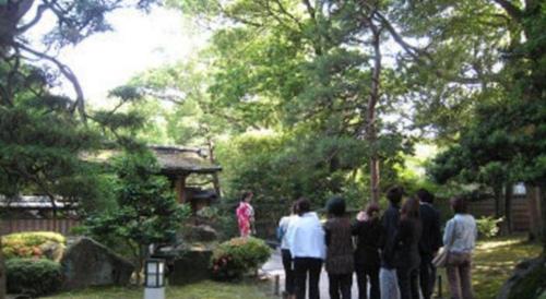 a group of people standing around in a garden at Green Hotel Yes Nagahama Minatokan in Nagahama