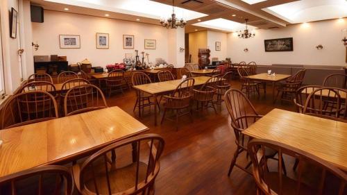 an empty restaurant with wooden tables and chairs at Petit Hotel Key West Club in Naha