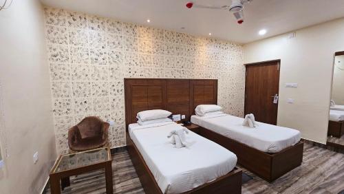 BalasoreにあるHotel Starwayのベッド2台と椅子が置かれた部屋