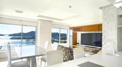 a dining room with a table and a television at Hamanako Lake Side Plaza in Hamamatsu