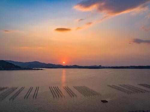 a large body of water with a sunset in the background at Hamanako Lake Side Plaza in Hamamatsu