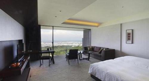 a hotel room with a bed and a living room at Nippondaira Hotel in Shizuoka
