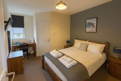 a bedroom with a bed with two towels on it at The Dolphin Hotel in Wincanton