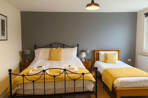 a bedroom with two beds with yellow and white pillows at The Dolphin Hotel in Wincanton