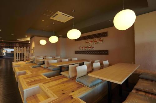 a restaurant with a long table and chairs and lights at HOTEL CLAD in Fuji