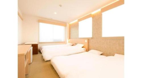 three beds in a room with three windows at NAMBA EBISU HOTEL in Osaka