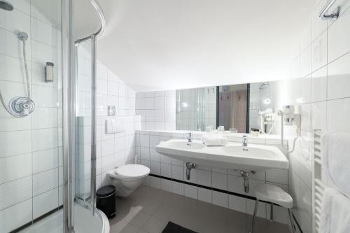 a white bathroom with a sink and a toilet at Crystls Aparthotel in Flachau