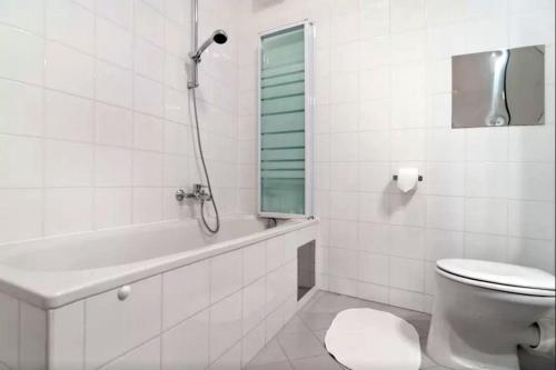 biała łazienka z toaletą i wanną w obiekcie cosy apartment in perfect location w Wiedniu
