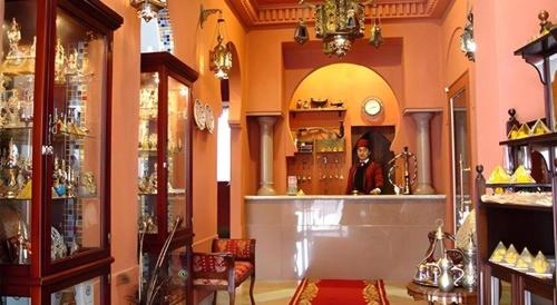 a man in a room with a counter in a store at Arabian Art Hotel & Gallery in Onjuku