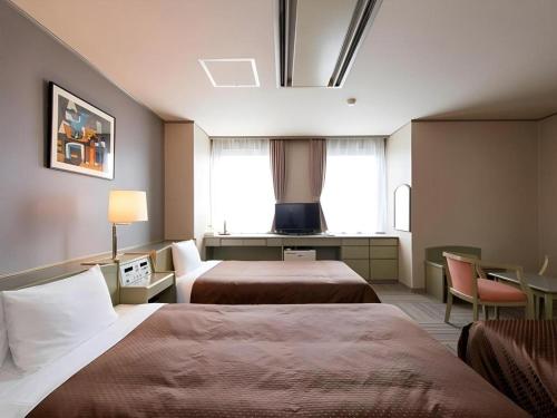 a hotel room with two beds and a window at New Biwako Hotel in Otsu