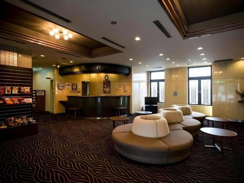 a lobby with a waiting area with couches and tables at New Biwako Hotel in Otsu