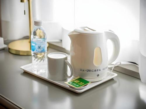 a coffee maker and a bottle of water on a counter at New Biwako Hotel in Otsu
