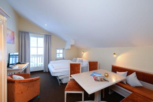 a hotel room with a bed and a table at Crystls Aparthotel in Flachau