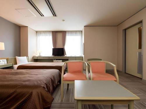 a hospital room with two beds and two chairs at New Biwako Hotel in Otsu