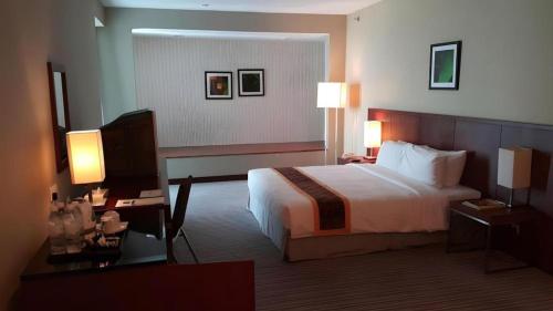 a hotel room with a bed and a television at RH Hotel Sibu in Sibu