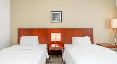 two beds in a hotel room with white sheets at RH Hotel Sibu in Sibu