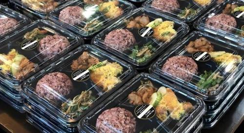 a display case filled with plastic containers of food at The Orchid Hotel in Sibu