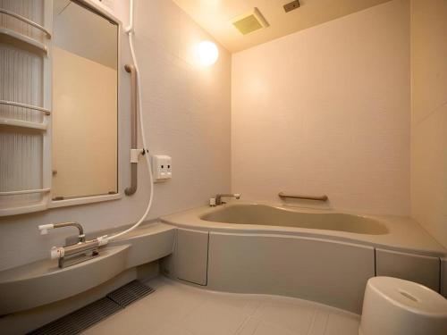 a bathroom with a tub and a toilet and a sink at New Biwako Hotel in Otsu