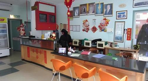 a woman standing at a counter in a restaurant at Hotel Hung Hung in Kuching