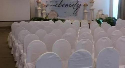 a row of white chairs in a room at RH Hotel Sibu in Sibu