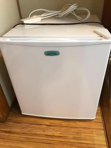 a white refrigerator sitting on top of a floor at HotelNewYama in Yamanouchi