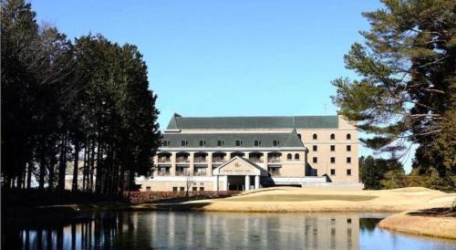 a large building with a lake in front of it at HOTEL WINDSOR in Nakatsugawa
