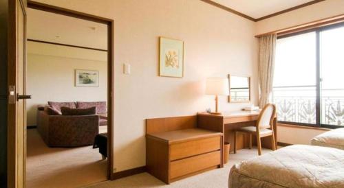 a hotel room with a desk and a bedroom at HOTEL WINDSOR in Nakatsugawa