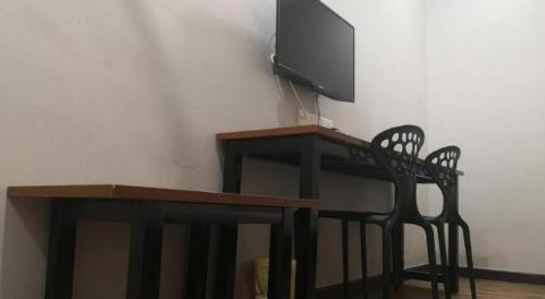 a table with a tv and a chair in a room at Pendang Suite Hotel PLT in Alor Setar