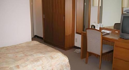 a room with a desk and a computer and a chair at Hotel Ito in Wakayama