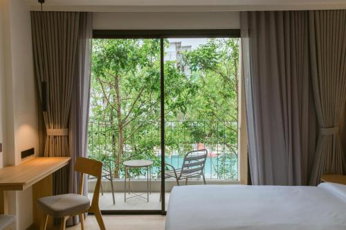 a hotel room with a bed and a large window at PAAK Hotel Suvarnabhumi in Lat Krabang