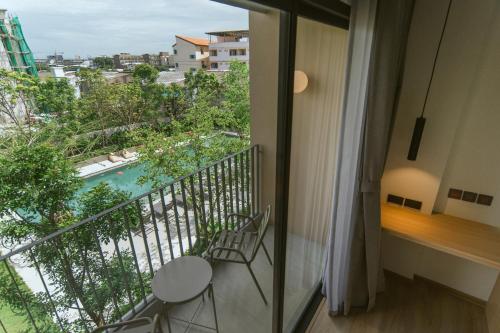 a balcony with two chairs and a view of a pool at PAAK Hotel Suvarnabhumi in Lat Krabang