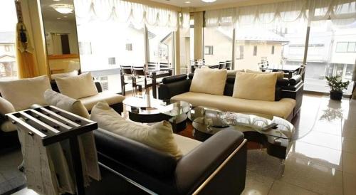 a large living room with couches and a table at Chino Station Hotel in Chino