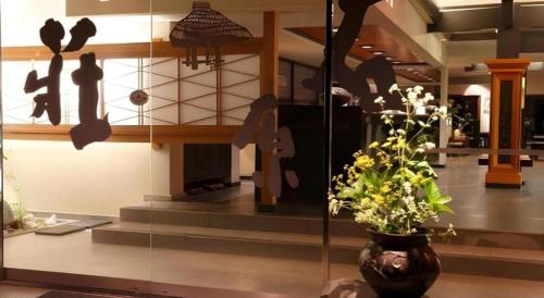 a lobby with a vase with a plant in it at Myoken Ishiharaso in Kirishima