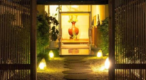 a house with a vase on the front porch with lights at Yukemuri no sato azumaya in Beppu