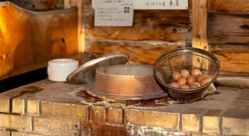 a bowl of eggs sitting on a counter with a mortar at Yukemuri no sato azumaya in Beppu