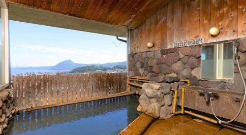 a pool of water in a room with a fence at Yukemuri no sato azumaya in Beppu