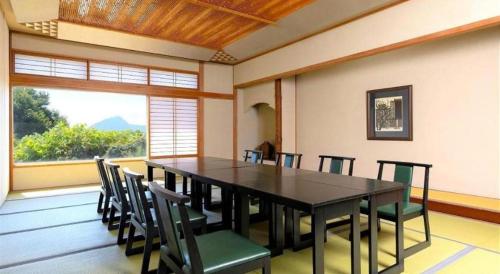 a large dining room with a table and chairs at Yukemuri no sato azumaya in Beppu