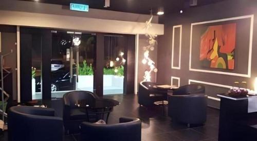 a restaurant with chairs and a table and a car at Cappuccino Hotel @ Mount Austin in Johor Bahru
