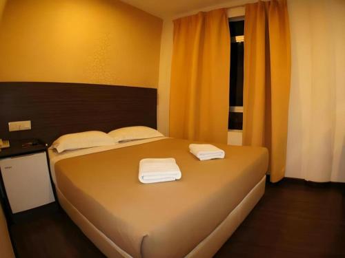 a bedroom with a bed with two towels on it at Cukai View Hotel in Cukai