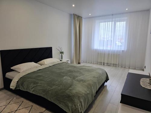 a bedroom with a large bed and a window at Новинка ЖК Тріумф поряд вокзалу in Luts'k