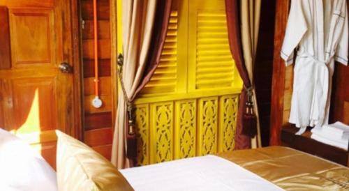 a bedroom with a yellow door and a bed at Kampong Pinang Sebatang Melaka in Melaka