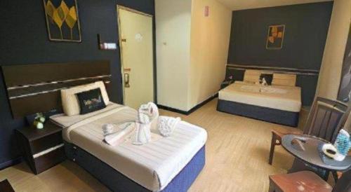 a hotel room with two beds and a bathroom at Alia Express Sendayan in Seremban