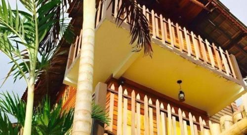 a yellow house with a palm tree in front of it at Kampong Pinang Sebatang Melaka in Melaka
