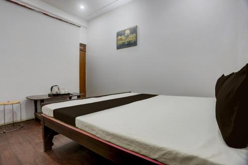 Un dormitorio con una cama en una habitación con una mesa. en SPOT ON S.M. HOTEL, en Ghoghāpur