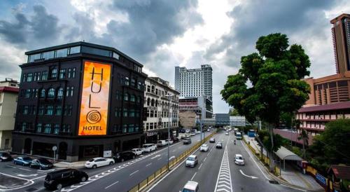 a busy city street with a building with an advertisement on it at The Hulo Hotel & Gallery in Kuala Lumpur