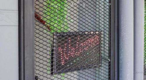 a wire mesh door with a bunch of red bottles at Big Orange Hotel Jitra in Alor Setar